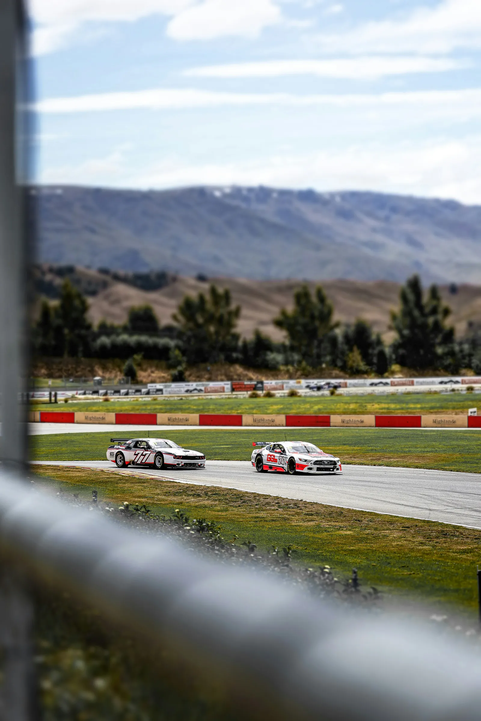 Two race cars with mountains